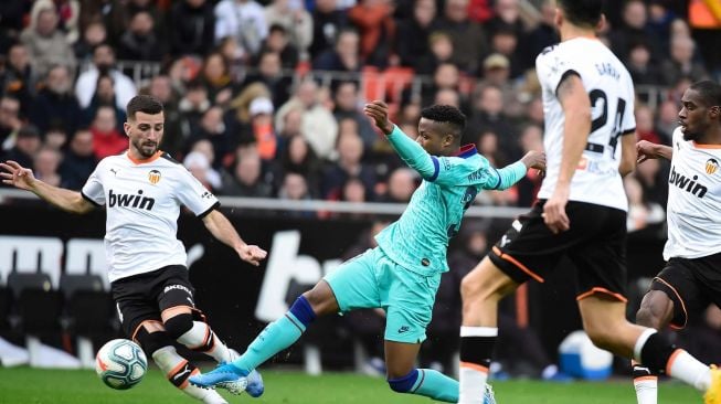 Bek Valencia Jose Luis Gaya Pena (kiri) menantang pemain depan Barcelona Ansu Fati (C) selama pertandingan sepak bola liga Spanyol Valencia melawan Barcelona di Stadion Mestalla, Valencia, Spanyol, Sabtu (26/1).[JOSE JORDAN / AFP]