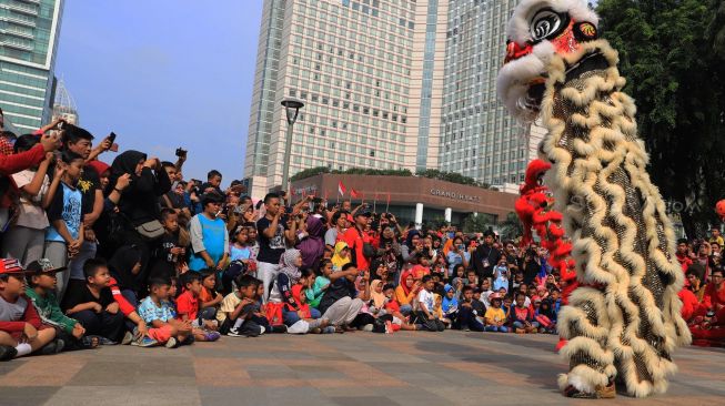 Sejumlah seniman beraksi memainkan barongsai saat berlangsungnya Car Free Day di Bundaran Hotel Indonesia, Jakarta, Minggu (26/1). [Suara.com/Alfian Winanto]