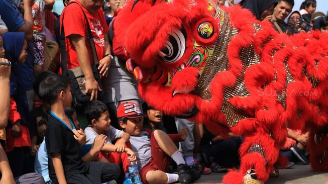 Sejumlah seniman beraksi memainkan barongsai saat berlangsungnya Car Free Day di Bundaran Hotel Indonesia, Jakarta, Minggu (26/1). [Suara.com/Alfian Winanto]
