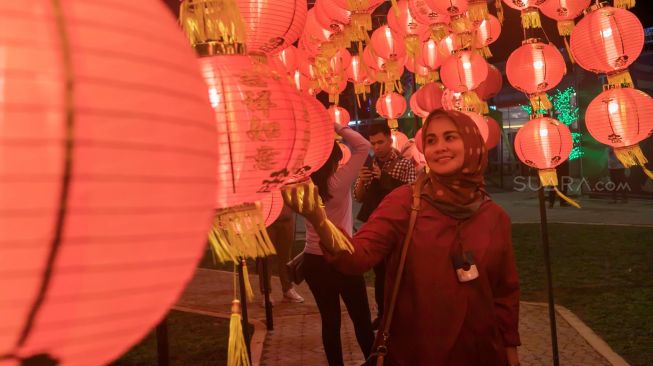 Pengunjung berswafoto di area Thamrin 10 yang di hiasi instalasi lampion dalam rangka merayakan Tahun Baru Imlek di Jakarta Pusat, Minggu (26/1). [Suara.com/Alfian Winanto]