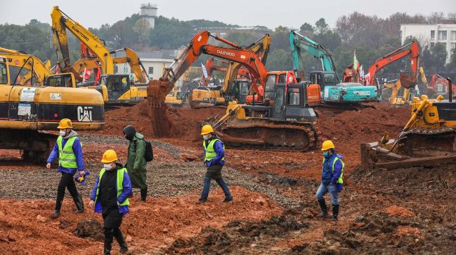 Para pekerja dan alat berat di lokasi pembanguan rumah sakit di Kota Wuhan, China. [Foto/AFP]