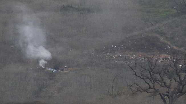 Helikopter jatuh dan mengeluarkan asap di Calabasas, California, Amerika Serikat, Minggu (26/1). [AFP Photo]