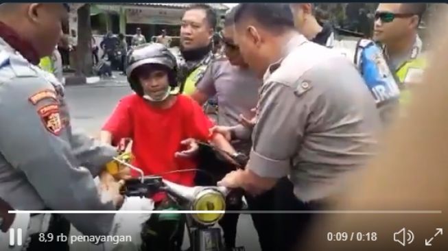 Seorang bocah di Jogja merengek saat ditilang petugas kepolisian, Minggu (26/1/2020) kemarin. [@merapi_news / Twitter]