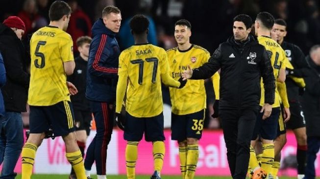 Manajer Arsenal Mikel Arteta (kanan) menyalami pemainnya setelah menang atas Bournemouth 2-1 di babak keempat Piala FA di Vitality. Glyn KIRK / AFP