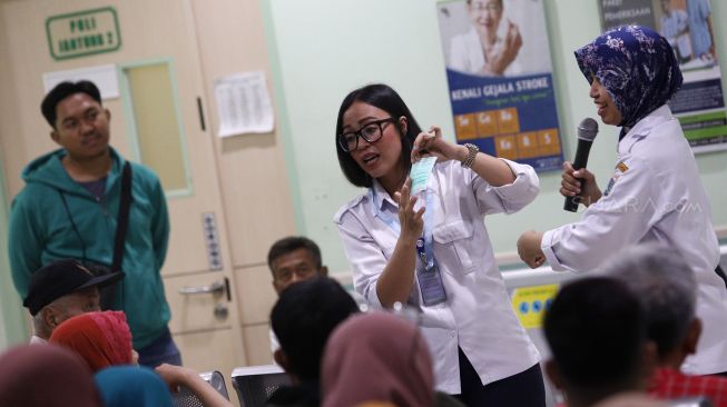 Petugas Pencegahan dan Pengendalian Infeksi (PPI) RSUD Pasar Minggu mempraktekkan cara memakai masker yang benar kepada pasien saat penyuluhan terkait pencegahan virus Corona (2019-nCoV) di RSUD Pasar Minggu, Jakarta Selatan, Rabu (29/1). [Suara.com/Angga Budhiyanto]