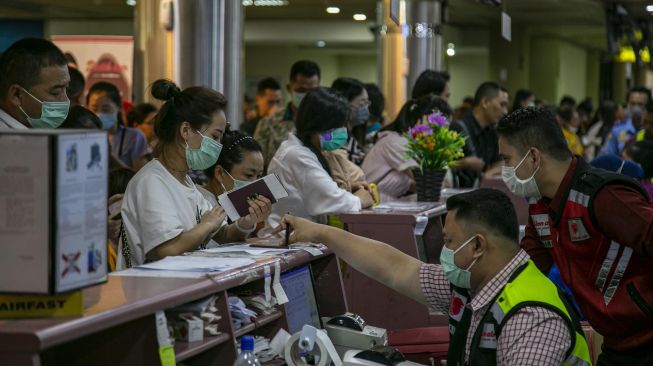 Sejumlah wisatawan asing asal China antre di konter lapor diri (check-in) Terminal Keberangkatan Bandara Hang Nadim, Batam, Kepulauan Riau, Selasa (28/1).  [ANTARA FOTO/M N Kanwa]