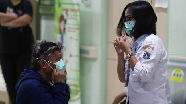 Petugas Pencegahan dan Pengendalian Infeksi (PPI) RSUD Pasar Minggu mempraktekkan cara memakai masker yang benar kepada pasien saat penyuluhan terkait pencegahan virus Corona (2019-nCoV) di RSUD Pasar Minggu, Jakarta Selatan, Rabu (29/1). [Suara.com/Angga Budhiyanto]  