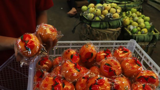 Aktivitas para pedagang di blok buah Pasar Induk Kramat Jati, Jakarta Timur, Rabu (29/01).  [Suara.com/Alfian Winanto]