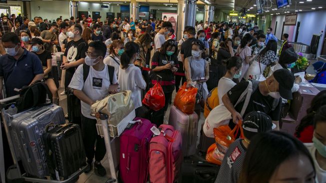 Sejumlah wisatawan asing asal China antre di konter lapor diri (check-in) Terminal Keberangkatan Bandara Hang Nadim, Batam, Kepulauan Riau, Selasa (28/1).  [ANTARA FOTO/M N Kanwa]