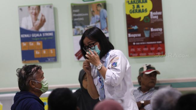 Petugas Pencegahan dan Pengendalian Infeksi (PPI) RSUD Pasar Minggu mempraktekkan cara memakai masker yang benar kepada pasien saat penyuluhan terkait pencegahan virus Corona (2019-nCoV) di RSUD Pasar Minggu, Jakarta Selatan, Rabu (29/1). [Suara.com/Angga Budhiyanto] 