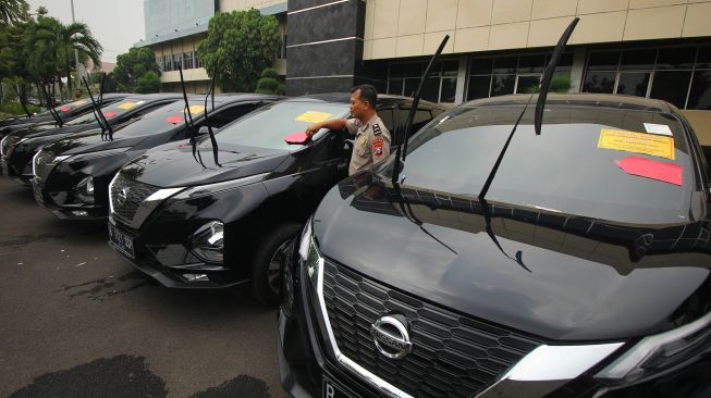 Polisi menunjukkan barang bukti mobil kasus investasi ilegal 'MeMiles' di Polda Jawa Timur, Surabaya, Jawa Timur, Selasa (28/1). [ANTARA FOTO/Didik Suhartono]