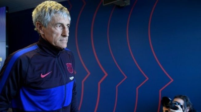 Pelatih Barcelona Quique Setien memasuki ruang konferensi pers di Joan Gamper. [AFP]