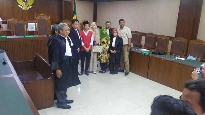 Terdakwa Dede Lutfhi Alfiandi saat berfoto bersama tim pengacara dan tokoh politik sebelum menjalani sidang vonis di PN Jakpus. (Suara.com/Stephanus Aranditio).