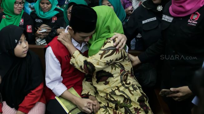 Lutfi Alfiandi (kiri) bersama dengan Ibunya Nurhayati Sulistya (kanan) saat menjalani sidang putusan di Pengadilan Negeri Jakarta Pusat, Kamis (30/01). [Suara.com/Alfian Winanto]