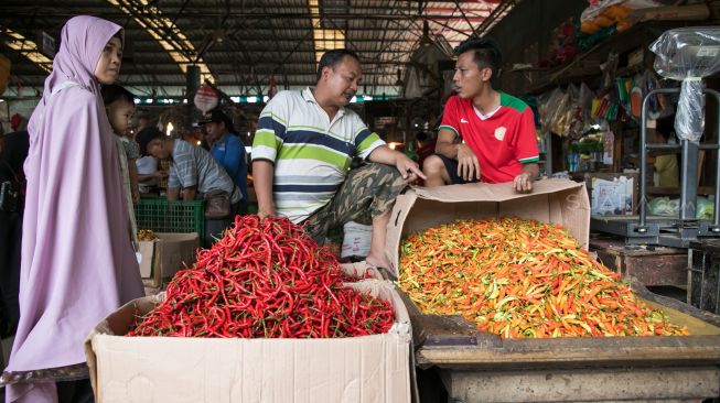 Pedagang cabai merapikan cabai di Pasar Induk Kramat Jati, Jakarta Timur, Kamis (30/01).[Suara.com/Alfian Winanto]