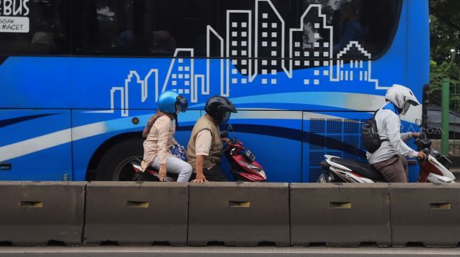 Pengendara sepeda motor berusaha menghindari razia Polisi lalu lintas di jalur khusus Transjakarta Sultan Agung, Manggarai, Jakarta, Jumat (31/1).  [Suara.com/Angga Budhiyanto]