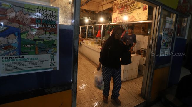 Pembeli membawa belanjaannya di dalam kantong plastik saat berbelanja di Pasar Tebet Barat, Jakarta, Jumat (31/1). [Suara.com/Angga Budhiyanto]
