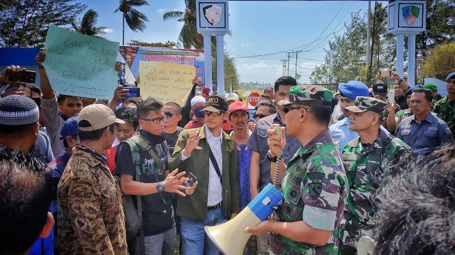 Sejumlah warga Natuna melakukan aksi unjuk rasa di depan gerbang pangkalan TNI Angkatan Udara Raden Sadjad, Ranai, Natuna, Kepulauan Riau, Sabtu (1/2).  [ANTARA FOTO/Cherman]
