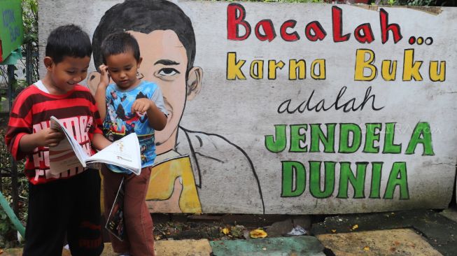 Anak-anak membaca buku di Kampung Literasi, Jatipulo, Palmerah, Jakarta Barat, Sabtu (01/02). [Suara.com/Alfian Winanto]
