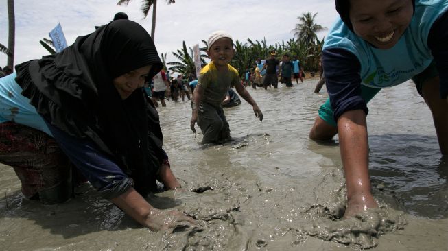 Para Petani bersama keluarganya berusaha menangkap ikan lele di dalam petakan sawah berisi air di Desa Towua, Kecamatan Wundulako, Kolaka, Sulawesi Tenggara, Sabtu (1/2). [ANTARA FOTO/Jojon]