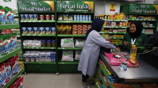 Seorang pembeli berbelanja di Multi Usaha Syariah (MUS) Halal Convenience Store, Meruyung, Depok, Jawa Barat, Minggu (2/2). [Suara.com/Angga Budhiyanto]