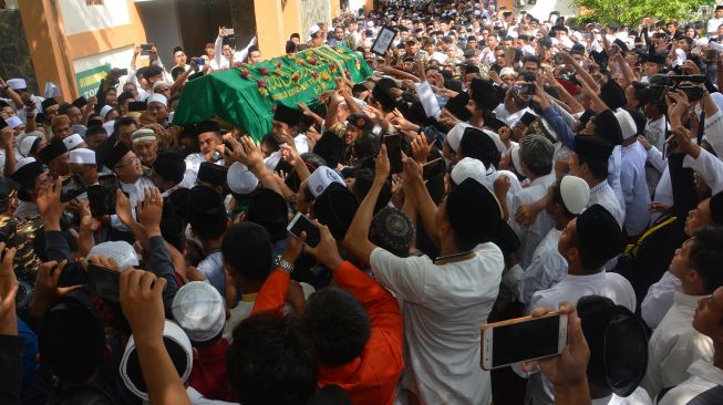 Ribuan santri berebut memegang keranda jenazah almarhum KH Salahuddin Wahid atau Gus Sholah saat dibawa ke masjid untuk disholati di Pesantren Tebuireng Jombang, Jawa Timur, Senin (3/2). [ANTARA FOTO/Syaiful Arif]