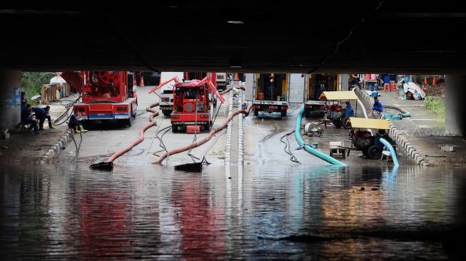 Petugas melakukan penyedotan air yang merendam underpass Kemayoran, Jakarta, Senin (3/2). [Suara.com/Angga Budhiyanto]