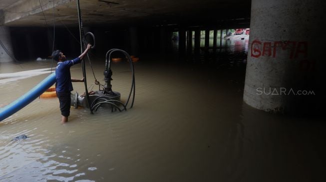 Petugas melakukan penyedotan air yang merendam underpass Kemayoran, Jakarta, Senin (3/2). [Suara.com/Angga Budhiyanto]