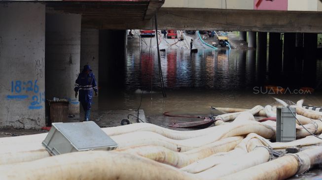 Petugas melakukan penyedotan air yang merendam underpass Kemayoran, Jakarta, Senin (3/2). [Suara.com/Angga Budhiyanto]