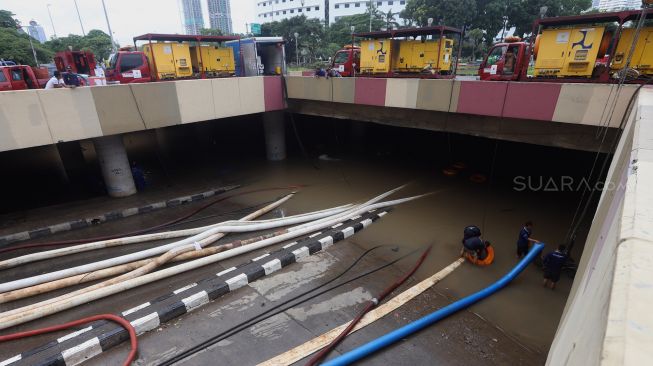 Petugas melakukan penyedotan air yang merendam underpass Kemayoran, Jakarta, Senin (3/2). [Suara.com/Angga Budhiyanto]