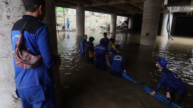 Petugas melakukan penyedotan air yang merendam underpass Kemayoran, Jakarta, Senin (3/2). [Suara.com/Angga Budhiyanto]