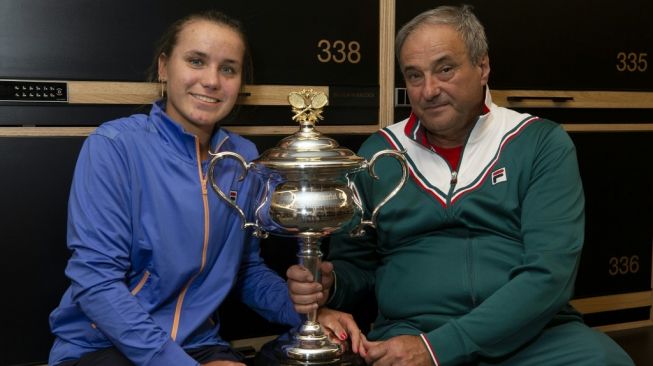 Sofia Kenin (kanan) berpose bersama sang Ayah yang juga pelatihnya, Alex Kenin, dengan trofi grand slam Australia Open 2020 yang diraih usai mengalahkan Garbine Muguruza (Spanyol), Minggu (2/2/2020). [AFP/Fiona Hamilton]