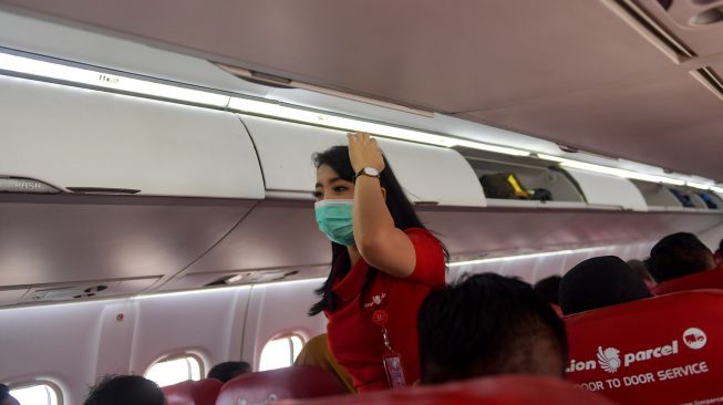 Pramugari maskapai Wings Air menggunakan masker saat melayani penerbangan menuju Ranai, Natuna di Bandara Hang Nadim, Batam, Selasa (4/2). [ANTARA FOTO/M Risyal Hidayat]
