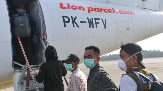 Penumpang maskapai Wings Air menggunakan masker saat akan menaiki pesawat di Bandara Hang Nadim, Batam, Selasa (4/2). [ANTARA FOTO/M Risyal Hidayat]