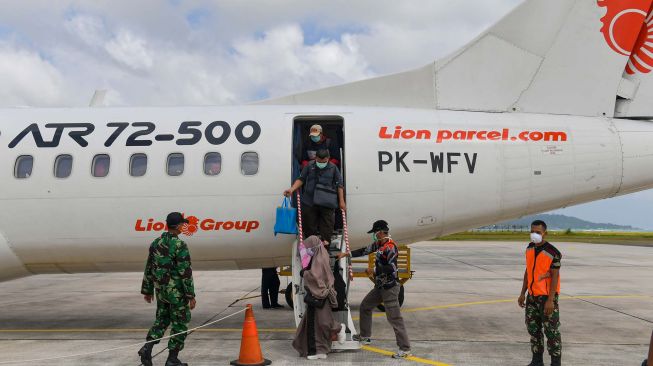 Sejumlah penumpang turun dari pesawat maskapai Wings Air menggunakan masker setibanya di Bandara Raden Sadjad, Ranai, Natuna, Kepulauan Riau, Selasa (4/2). [ANTARA FOTO/M Risyal Hidayat]