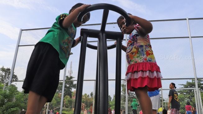 Anak-anak bermain di Taman Delonix yang berada di Jalan Tipar Pasar Rebo, Jakarta Selatan, Selasa (04/02).  [Suara.com/Alfian Winanto]