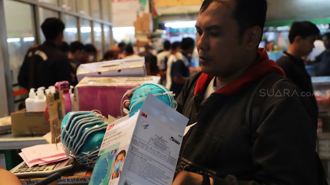 Pembeli memilih masker di Pasar Pramuka, Jakarta Timur, Rabu (05/02). [Suara.com/Alfian Winanto]