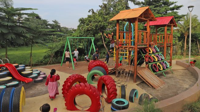 Anak-anak bermain di Taman Delonix yang berada di Jalan Tipar Pasar Rebo, Jakarta Selatan, Selasa (04/02).  [Suara.com/Alfian Winanto]