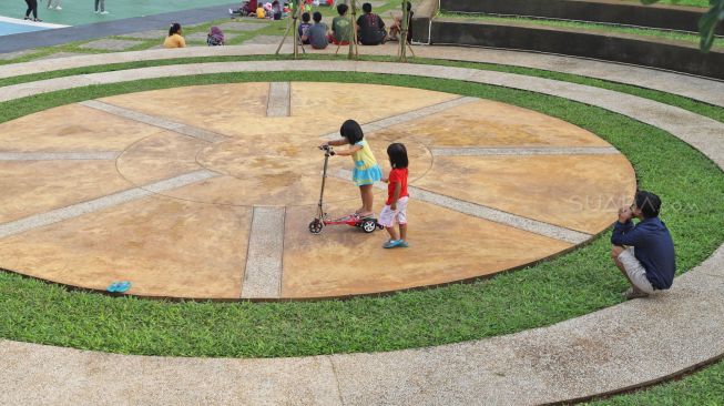 Anak-anak bermain di Taman Delonix yang berada di Jalan Tipar Pasar Rebo, Jakarta Selatan, Selasa (04/02).  [Suara.com/Alfian Winanto]