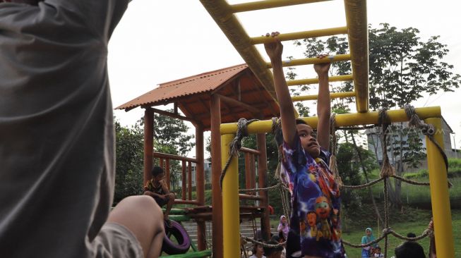 Anak-anak bermain di Taman Delonix yang berada di Jalan Tipar Pasar Rebo, Jakarta Selatan, Selasa (04/02).  [Suara.com/Alfian Winanto]