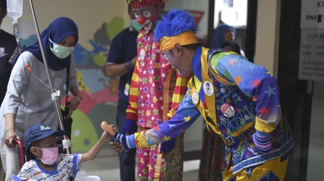 Dua badut yang tergabung dalam Aku Badut Indonesia (ABI) memberikan mainan ke anak yang dirawat di salah satu rumah sakit di Jakarta, Kamis (6/2). [ANTARA FOTO/Wahyu Putro]