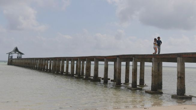 Dua orang anak berjalan di atas Dermaga Pengadah, Natuna, Kepulauan Riau, Jumat (7/2). [ANTARA FOTO/M Risyal Hidayat]