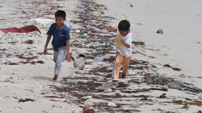 Dua orang anak berlari di pantai kawasan Dermaga Pengadah, Natuna, Kepulauan Riau, Jumat (7/2). [ANTARA FOTO/M Risyal Hidayat]
