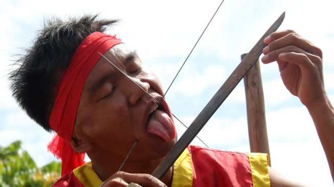 Sejumlah tatung (dukun Tionghoa yang kerasukan arwah leluhur) menjilat pisau saat beratraksi di acara perayaan Cap Go Meh di Sungai Raya, Kabupaten Kubu Raya, Kalimantan Barat, Sabtu (8/2). [ANTARA FOTO/Jessica Helena Wuysang]