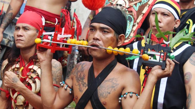 Seorang tatung (dukun Tionghoa yang kerasukan arwah leluhur) menusukan pipiny dengan besi tajam saat beratraksi di acara perayaan Cap Go Meh di Sungai Raya, Kabupaten Kubu Raya, Kalimantan Barat, Sabtu (8/2). [ANTARA FOTO/Jessica Helena Wuysang]