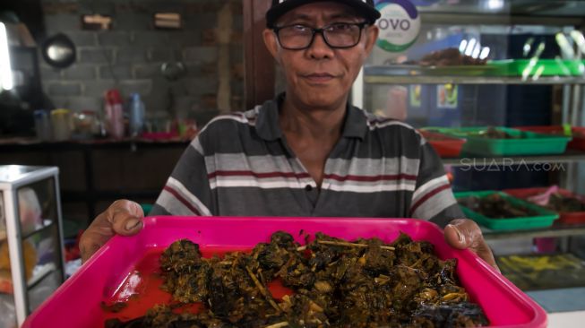 Pak Paulus menunjukkan Paniki makanan khas Manado yang terbuat dari Kelelawar di 'Warong Nyong', Jakarta Barat, Sabtu (08/02).[Suara.com/Alfian Winanto]