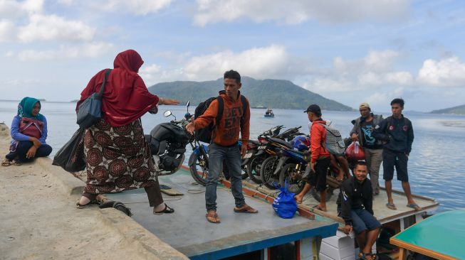 Penumpang menaiki kapal motor di Dermaga Pelabuhan Selat Lampa, Natuna, Kepulauan Riau, Sabtu (8/2).  [ANTARA FOTO/M Risyal Hidayat]