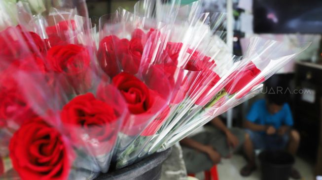 Pedagang merangkai bunga mawar di Pasar Bunga Rawa Belong, Jakarta Barat, Selasa (11/2). [Suara.com/Alfian Winanto]