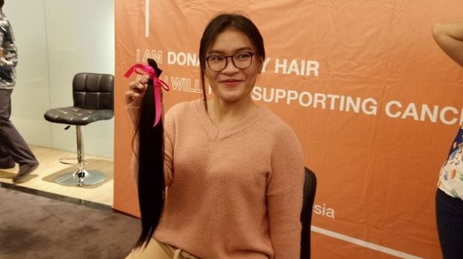 Perempuan menyumbangkan rambut panjangnya untuk mendukung penderita kanker. (Suara.com/Silfa Humairah)