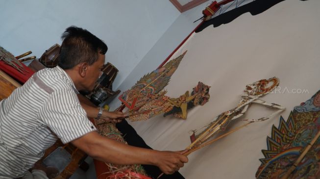 Dalang wayang Jawa Timuran, Ki Puguh Prasetyo, saat memainkan wayang-wayangnya. [Suara.com / Arry Saputra]